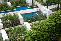 Linear rills and canals reminiscent of the Alhambra in Spain. A trulli building with conical drystone roof - RHS Chelsea Flower Show 2012
