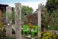 Pudding stone columns create a sustainable landscape, with chairs made from recycled bottles. A mix of ferns and Mediterranean planting - The Renault Garden, RHS Chelsea Flower Show 2012