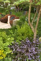 Tranquillity set in Stone. Bronze Medal Winner. Chelsea Flower Show 2012. Birds nest seating set into bed rock of woodland area.