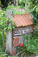Insect habitat made from recycled materials with a tiled roof 