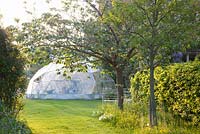 Geometric dome greenhouse in country garden 