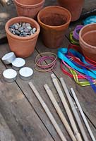 Materials needed for making garden tealight holders - Plant pots, bamboo canes, elastic bands, ribbons and shingle