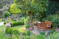 Feng shui themed garden with Prunus avium planted near seating area