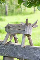 Carved wooden cow ornament on fence 