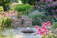 Chairs with border of Echinacea 'Razzmatazz', Echinace pallida, Eupatorium 'Glutball', Sanguisorba, Monarda 'Marshall's Delight' and Pennisetum orientale 'Karley Rose'