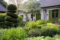 Courtyard with relaxing area surrounded with low hedging, De Romantische tuin - The Romantic Garden of Dina Deferme and Tony Pirotte