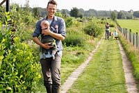 Martin Heutink and his wife Margriet with their two children Nina and Sven walking on the path in the wild garden - Nursery Bloemrijk