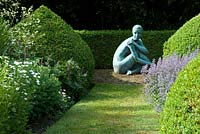 Isobel, bronze statue at the end of the grass path by the sculptor Anne Curry ARBS.  Buxus and perennials including Nepeta at Newland End Gardens, 25 June