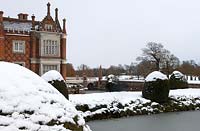 Large country house in snow with surrounded by moat