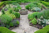 The sunken garden enclosed with Buxus curving hedges, with central antique stone trough raised pond water feature. Draught tolerant plants include Anthemis tinctoria, Erysimum 'Bowles' Mauve', Iris', Bergenias, Lavandula, Sage,Echinops, Artemesia and Achillea.