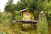 Garden shed next to pond with wooden landing