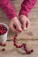 Step-by-step - threading cranberries onto wire heart shaped frame - creating decoration