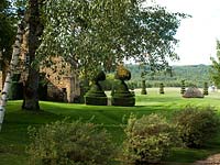 Taxus Baccata. Yew tree clipped as tiered topiary in classic style and strategically placed to accentuate the vista. Le Manoir d'Eyrignac, Dordogne, Perigord, France.