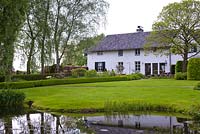 View of the garden with pond in foreground backed by house, De Carishof