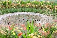 Circular pebble pool with spreading circles of Cosmos atrosanguineus, Achillea, Crocosmia and grasses in the 'To The Beat' garden. Gold medal winner and Best Orchestra Garden - RHS Tatton Flower Show 2012