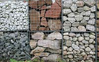 Steel gabions used as a dividing wall and filled with pebbles and stone in contrasting colours and textures