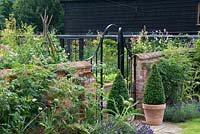 Boundary wall, gate and pots of box topiary
