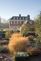 Formal garden in winter with Sedum, Calamagrostis acutiflora, clipped Buxus - Winfield House
