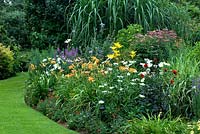Wildlife conservation garden with border of grasses, Lythrum, Hemerocallis - Daylilies, Lilium, Dahlia, Chrysanthemum and Leucanthemum