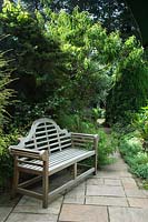 Lutyens bench on small patio in wildlife conservation garden
