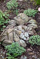 Stone statue amongst Sedum - Millennium Garden, Lichfield in spring