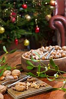Nuts and nutcrackers on a table at home with Christmas tree in the background