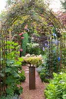 Metal archways with climber and mixed borders