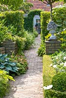 Pathway leading to a clipped archway in hedge