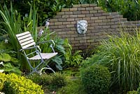 Relaxing area near the pond with a wall mounted water feature
