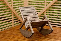 Wooden rocking chair in corner of garden 