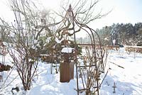 Garden in winter with metal gazebo