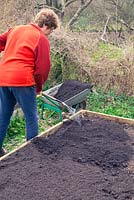 Using composted municipal waste to fill a raised bed.