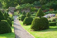 Sloping walled garden features topiary inspired by that at Lytes Carey in Somerset, with beds and path laid out to Voysey's original plan - Perrycroft, Upper Colwall, Herefordshire, UK