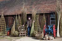Willow weaver Dominic Parrette with a variety of his creations, plants supports, sculptural sphere, Gypsy chair, trugs and baskets - Sussex Willow 
