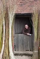 Willow weaver Dominic Parrette with semi-green willow in bundles outside barn - Sussex Willow 

