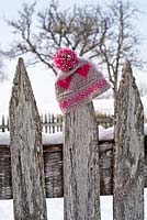 Bobble hat on wooden fence