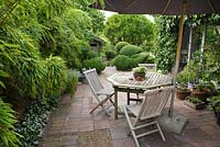 Terrace of terracotta tiles and bricks. Plants include Bamboo and Buxus - Box balls - Ulla Molin 
