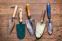 Old hand trowels on a wooden surface