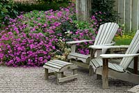 Garden chairs and footstool against a background swathe of Hardy Geranium 'Ann Folkard' - De Tuinen van Appeltern, Holland