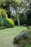 Wooden seat and formal lawn with Erica border - Great Comp, Kent