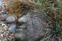 Libertia perigrinans and Carex as hair on decorative stone face