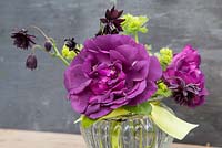 Flower arrangement in glass jar of Rosa 'Rhapsody in Blue', Aquilegia 'Black Barlow' and Alchemilla mollis