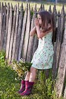 Girl whistling with a blade of grass.