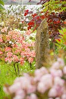 Standing stone by deciduous Azaleas, Acer and Sorbus  