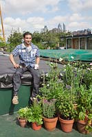 The Thames Garden Barges. Tenant Ruben's barge and his potted garden with Sweet Peas, Chard, Lavandula, Sedum, Nasturtians and herbs and city views of Tower Bridge and The Gherkin.