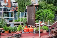 The Thames Garden Barges. Jess Turtle's barge with pots of herbs and Sweet Peas, Betula, Festuca and Sedum.
