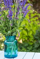 Salvia nemorosa 'Ostfriesland' arranged in blue glass vase