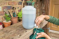 Step by step -  Filling watering can with homemade nettle fertilizer
