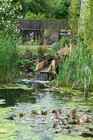 Modern water feature supplying garden pond through constructed wooden rills - Open Gardens Day 2013, Bardwell, Suffolk