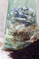 A 100% biodegradable compost bag full of vegetable peeling, shredded paper and teabags ready to go in the compost